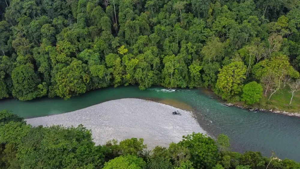Luftaufnahme des Flusses bei Tangkahan mit Kiesbank, umgeben vom Regenwald am Rand des Gunung-Leuser-Nationalparks